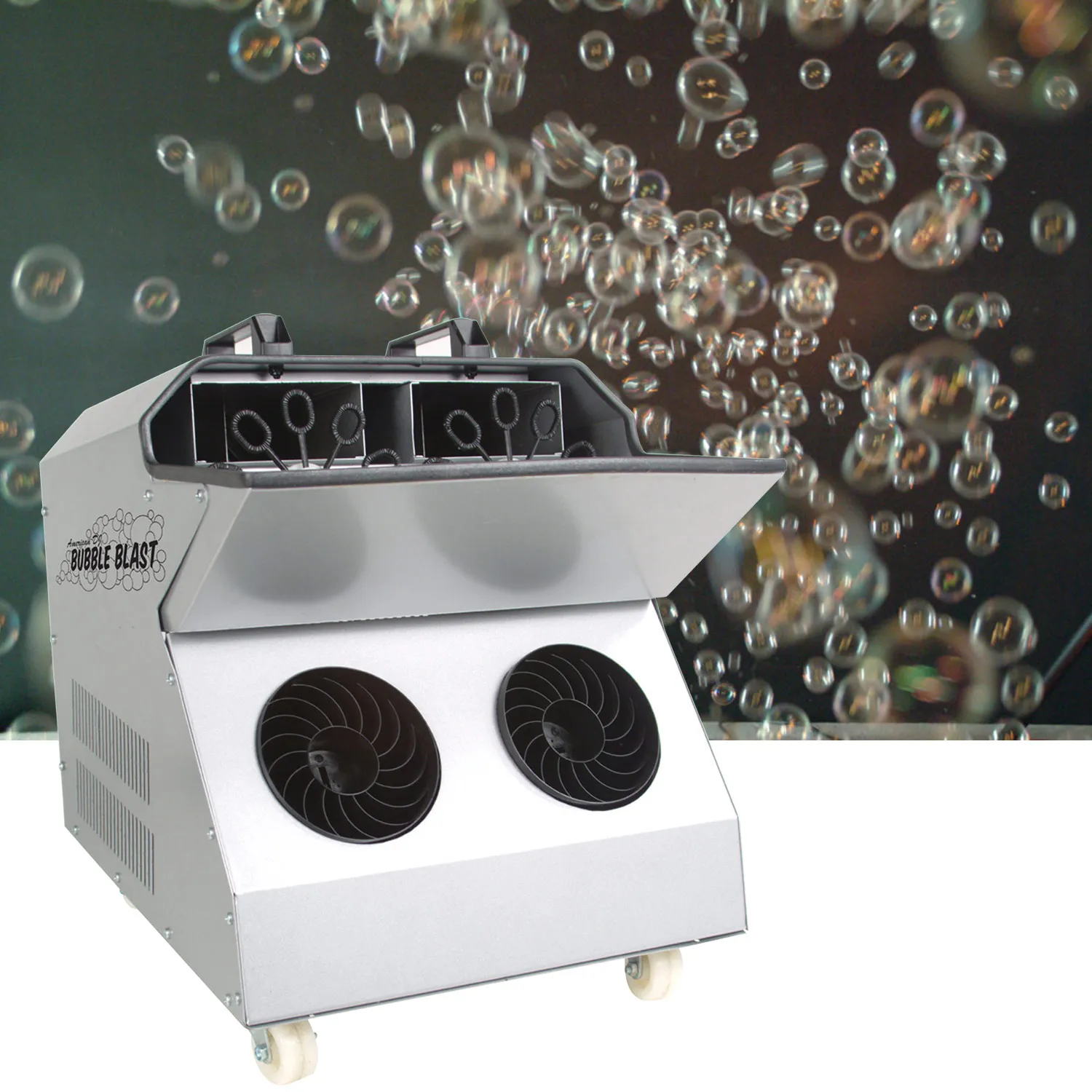 Silver bubble machine with two round fans and bubble wands on caster wheels, with soap bubbles floating behind it
